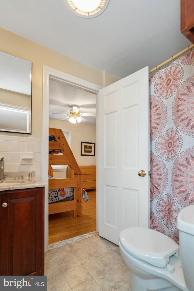 bathroom featuring toilet, ceiling fan, and vanity