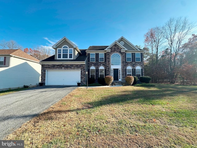 view of front of home with driveway, a front lawn, an attached garage, and stone siding