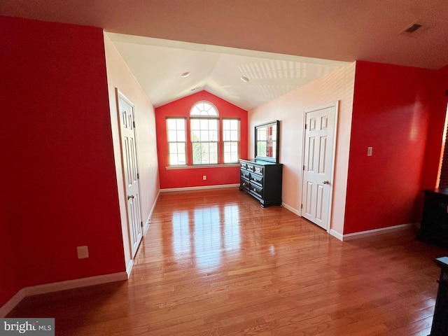 additional living space featuring lofted ceiling, wood finished floors, and baseboards