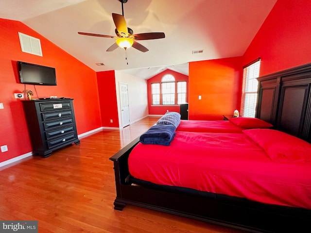 bedroom featuring lofted ceiling, visible vents, and wood finished floors