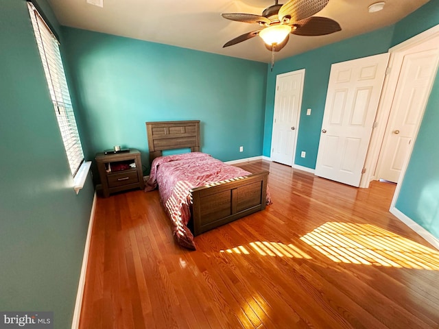 bedroom featuring wood-type flooring, baseboards, and ceiling fan