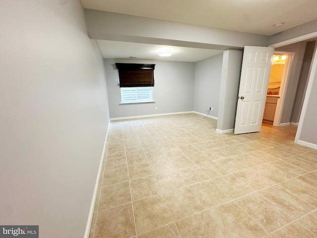 below grade area with baseboards and light tile patterned flooring