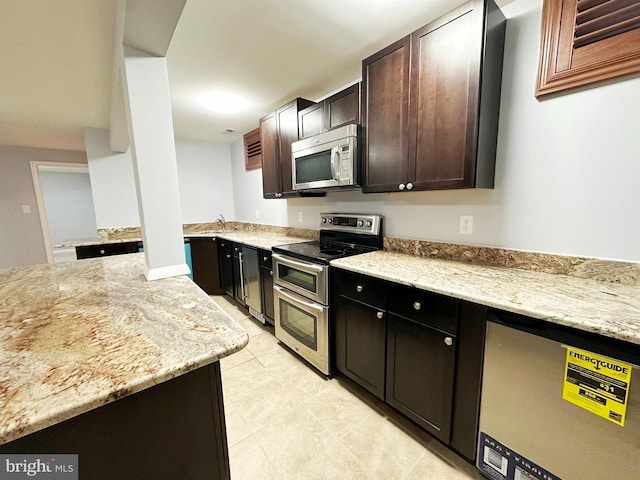 kitchen featuring a sink, appliances with stainless steel finishes, dark brown cabinets, and light stone counters