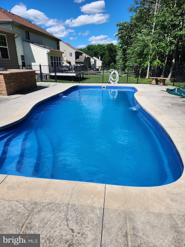 view of swimming pool featuring a patio, fence, and a fenced in pool