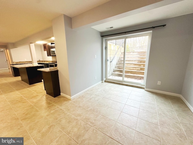 kitchen with visible vents, baseboards, a kitchen island, stainless steel appliances, and light countertops