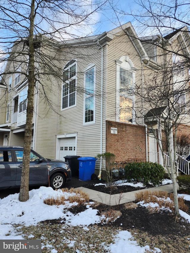 snow covered property featuring a garage