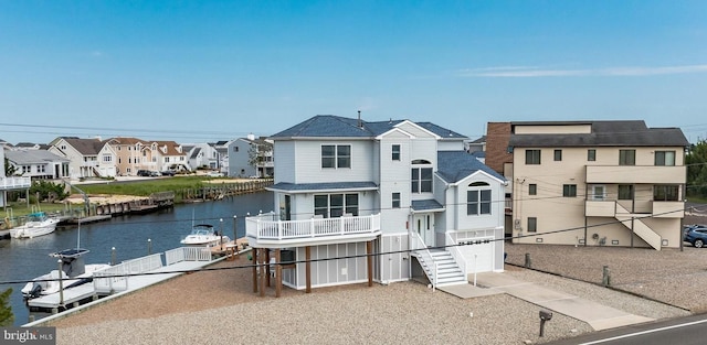 rear view of property featuring a garage, a balcony, and a water view