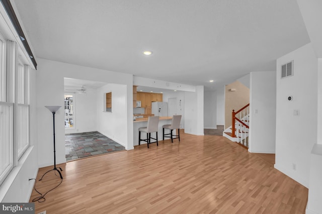 living room with light hardwood / wood-style floors and ceiling fan