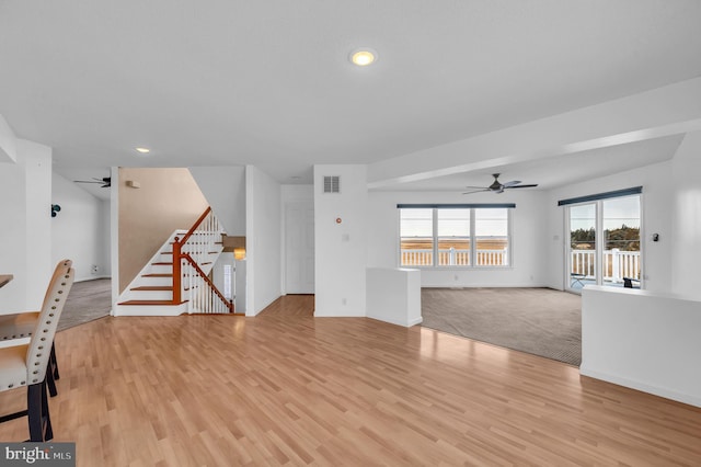 unfurnished living room with light hardwood / wood-style flooring and ceiling fan