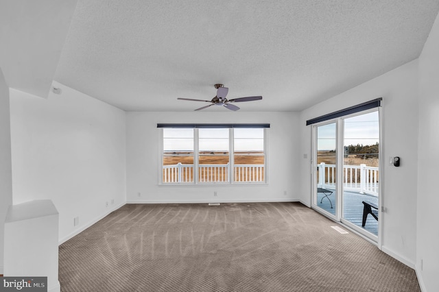 carpeted empty room featuring ceiling fan and a textured ceiling