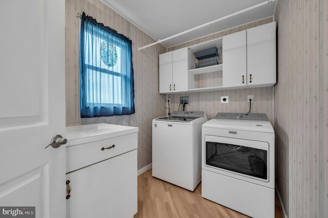 washroom with light wood-type flooring, cabinets, and independent washer and dryer