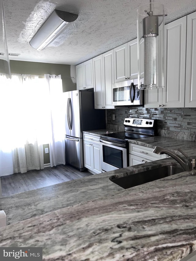 kitchen with light wood-type flooring, stainless steel appliances, sink, and white cabinets