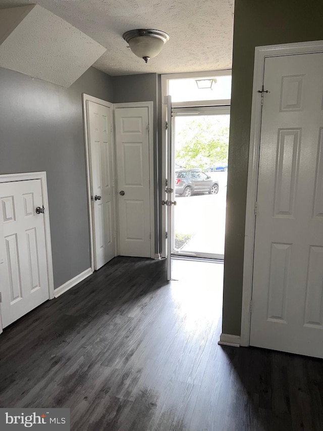 entryway with dark hardwood / wood-style flooring and a textured ceiling