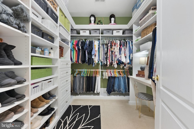 walk in closet featuring light colored carpet