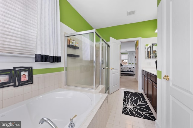 bathroom featuring tile patterned flooring, shower with separate bathtub, and vanity