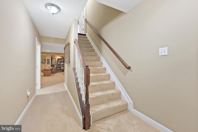 stairs featuring carpet flooring