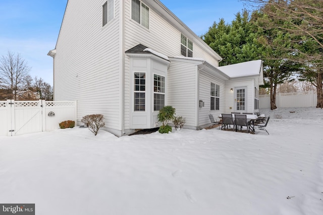 view of snow covered rear of property