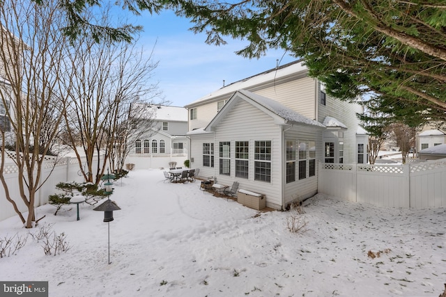 view of snow covered back of property