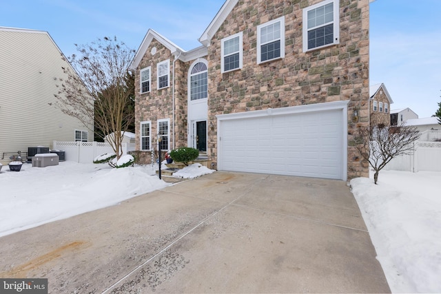 view of front of property featuring central AC and a garage