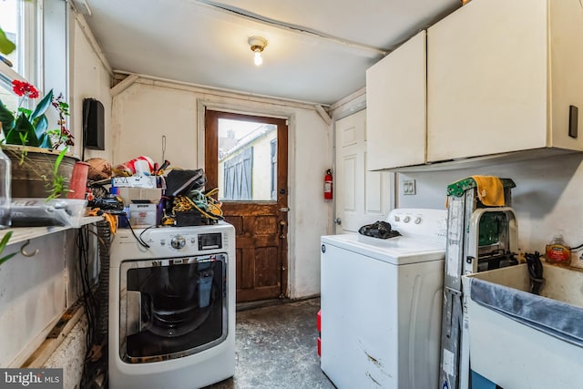 washroom with washing machine and dryer, cabinets, and sink