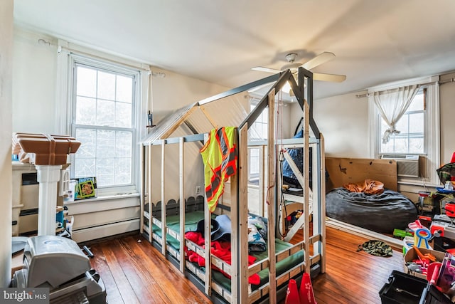 bedroom featuring ceiling fan, baseboard heating, and dark hardwood / wood-style floors