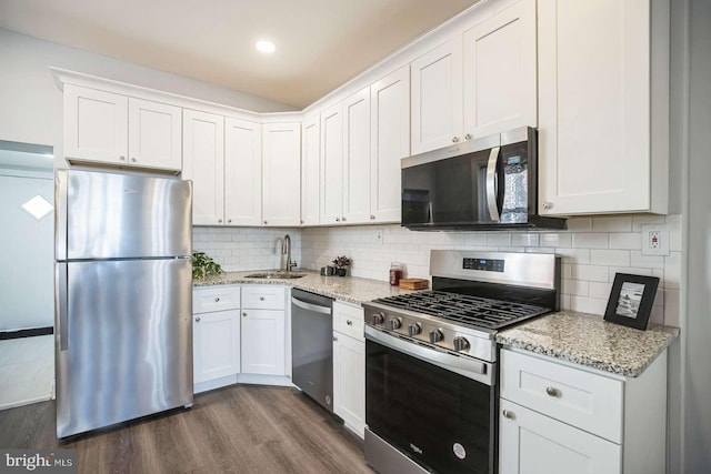 kitchen featuring tasteful backsplash, sink, white cabinets, and appliances with stainless steel finishes