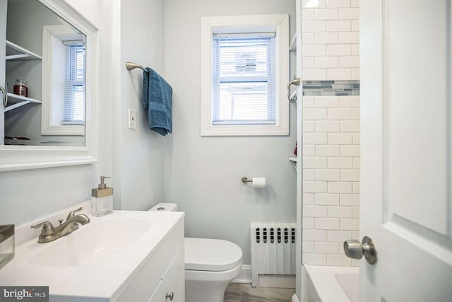 bathroom featuring vanity, toilet, and radiator heating unit