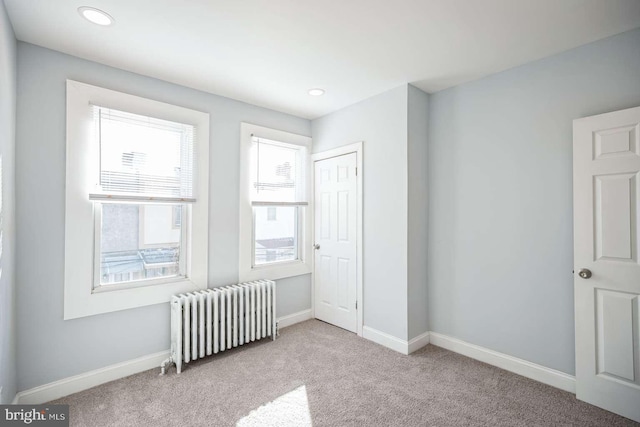 interior space with light carpet, a closet, and radiator