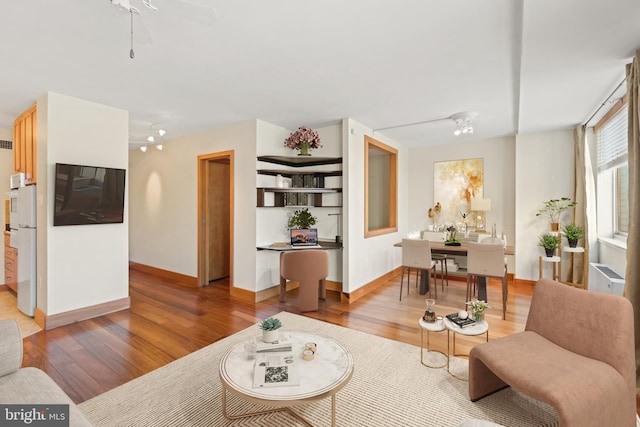 living room with wood-type flooring and ceiling fan with notable chandelier