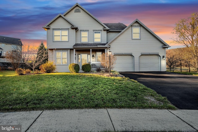 front facade featuring a garage, a porch, and a lawn