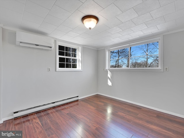 spare room featuring dark hardwood / wood-style floors, a wall unit AC, and a baseboard heating unit