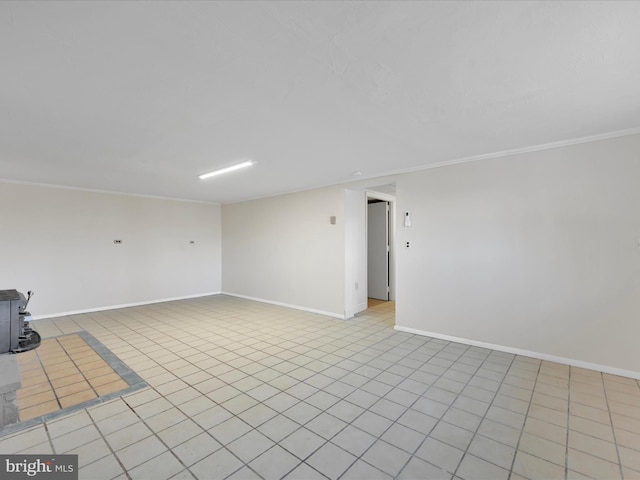 unfurnished room with crown molding, a wood stove, and light tile patterned floors