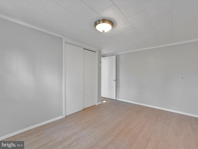 empty room with ornamental molding and light hardwood / wood-style flooring