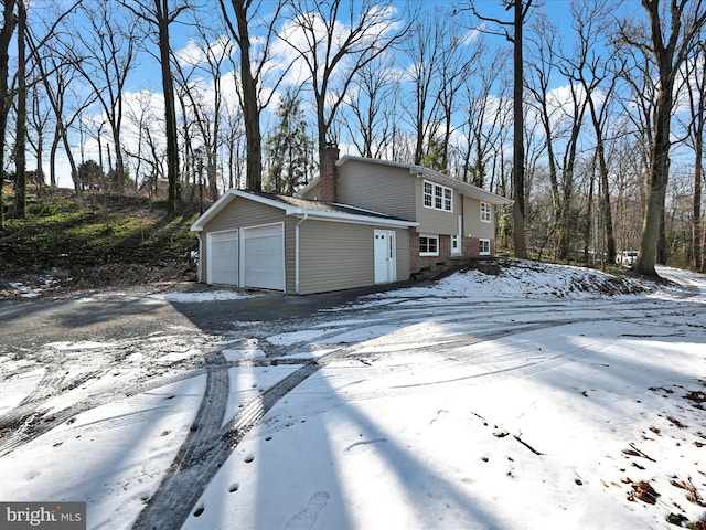 snow covered property with a garage