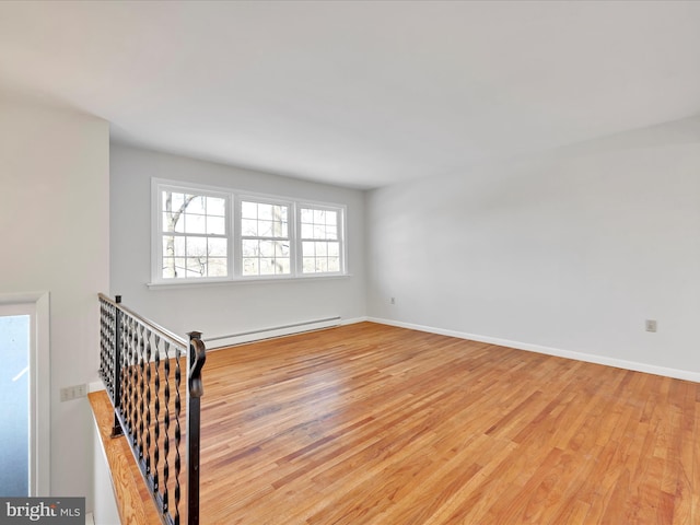 empty room featuring light wood-type flooring and a baseboard radiator