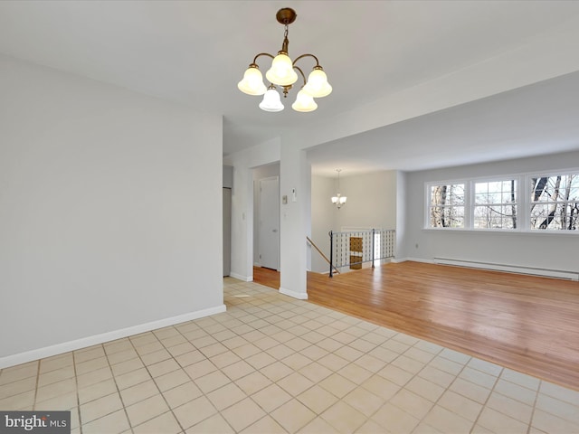 empty room with a baseboard heating unit, light tile patterned flooring, and a notable chandelier