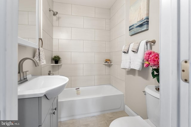 full bathroom with tiled shower / bath, vanity, and toilet