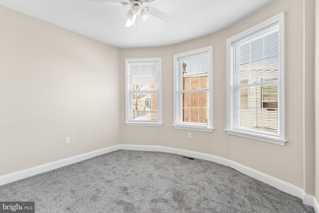 carpeted spare room featuring ceiling fan