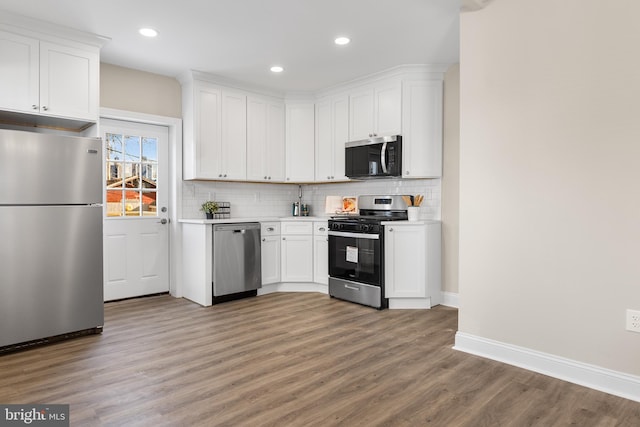 kitchen with backsplash, stainless steel appliances, dark hardwood / wood-style floors, and white cabinetry