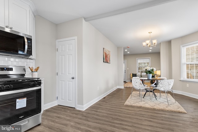 dining room featuring dark wood-type flooring, an inviting chandelier, and plenty of natural light