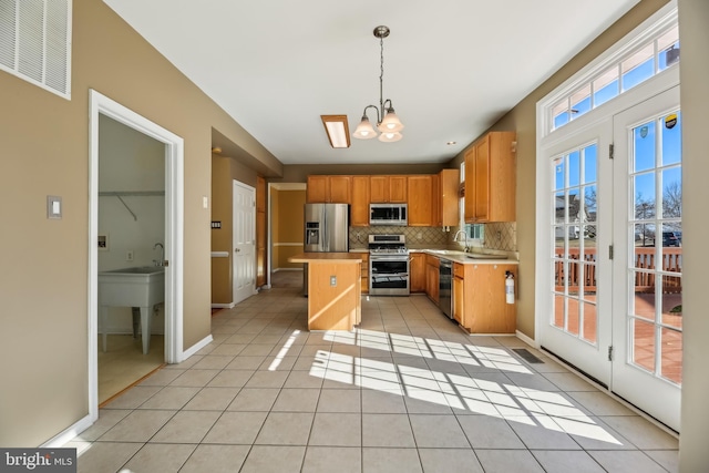 kitchen with appliances with stainless steel finishes, visible vents, a sink, and light tile patterned flooring