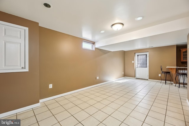 basement featuring baseboards and light tile patterned floors