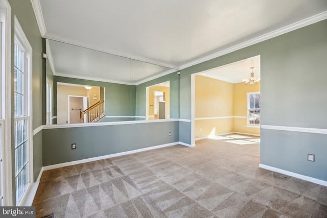 carpeted empty room featuring ornamental molding, stairway, baseboards, and an inviting chandelier