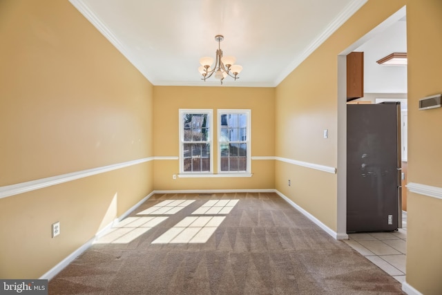 carpeted empty room featuring a notable chandelier, baseboards, crown molding, and tile patterned floors