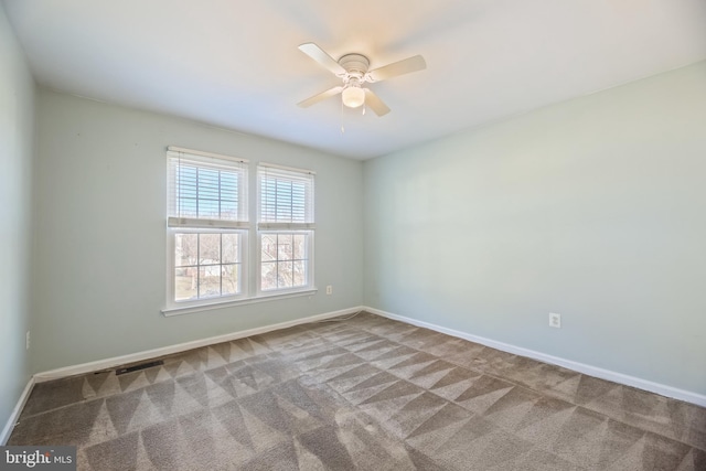 carpeted empty room featuring visible vents, baseboards, and a ceiling fan