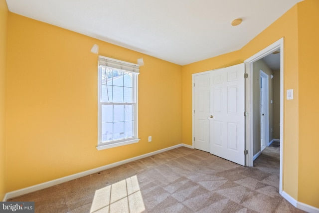 unfurnished bedroom featuring carpet floors and baseboards