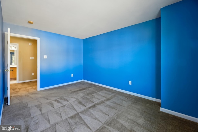 carpeted spare room with baseboards