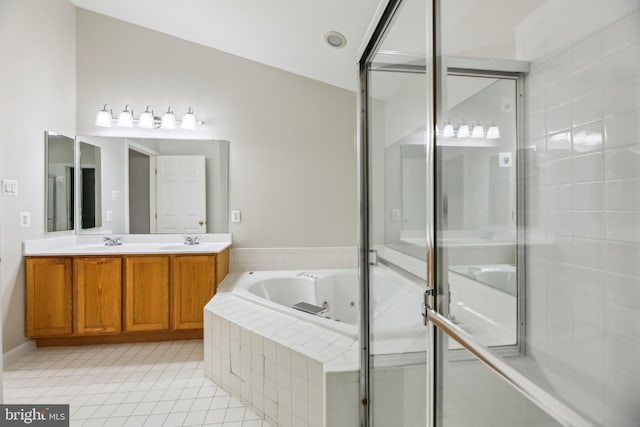 bathroom featuring a whirlpool tub, double vanity, a sink, and tile patterned floors