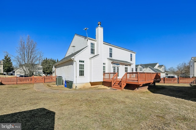 rear view of house with a deck, fence, a lawn, and central AC unit