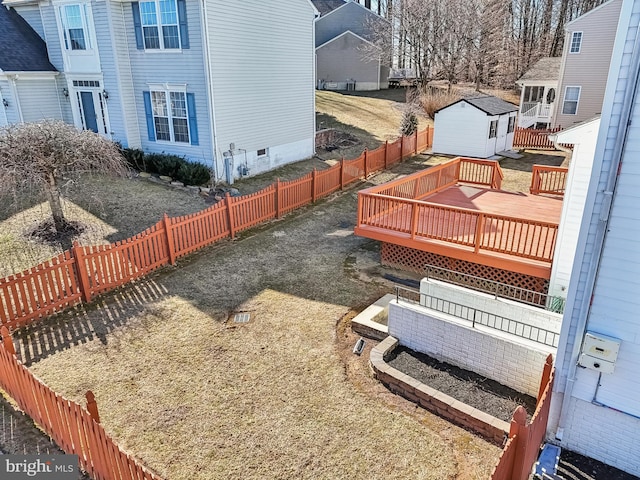 view of yard featuring a fenced backyard, a residential view, an outdoor structure, and a wooden deck